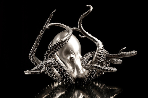 A octopus made of silver, isolated on black background.