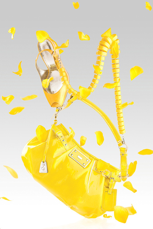 Bright yellow handbag, high heel pumps and confetti