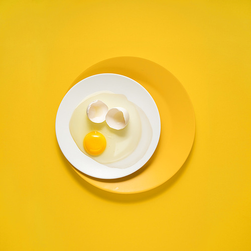 Creative concept photo of kitchenware, painted plate with food on it on yellow background.