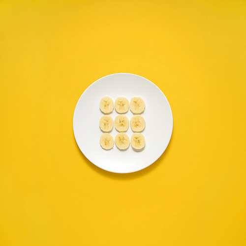 Creative concept photo of painted plates on yellow background.