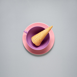 Creative concept photo of kitchenware, painted plate with food on it on grey background.