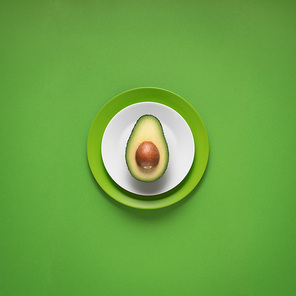 Creative concept photo of kitchenware, painted plate with food on it on green background.