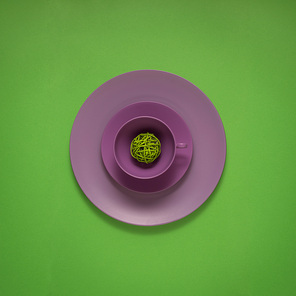 Creative concept photo of painted plates on green background.