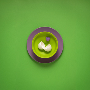 Creative concept photo of painted plates on green background.