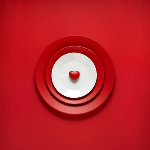 Creative concept photo of painted plates on red background.