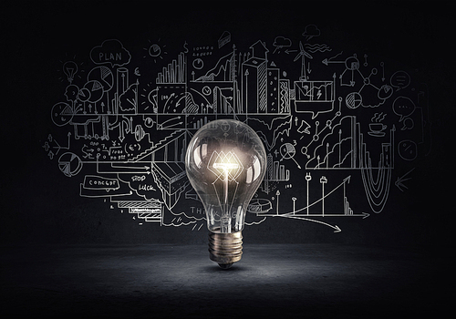 Glowing glass light bulb and business sketches at dark background