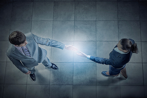 Top view of a businessman and woman shaking hands in office lobby