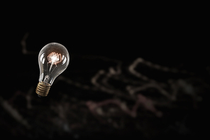 Glowing glass light bulb on dark background
