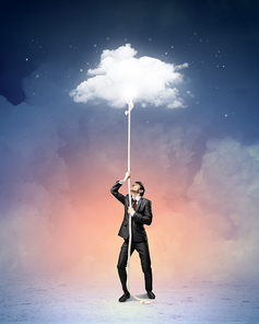 Image of businessman climbing rope attached to cloud