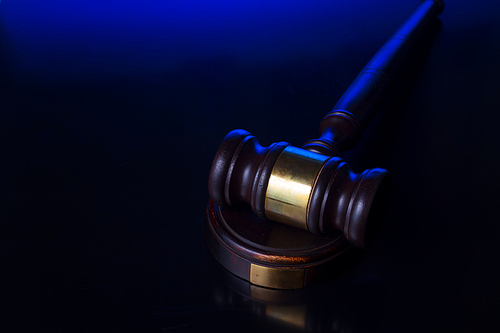 Law and justice concept - wooden law gavel pn blue and black background