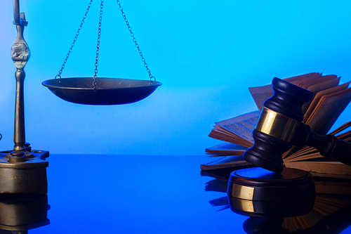 Law and justice concept - law gavel with open book and vintage scale in background