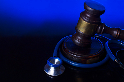 Wooden law gavel with stethoscope - medical law and justice concept
