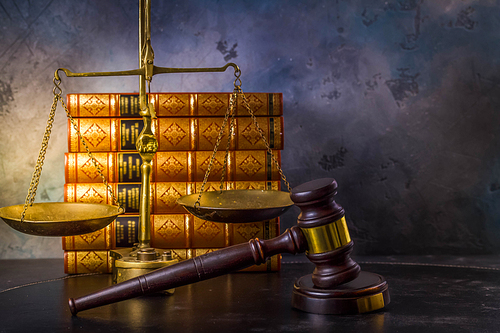 Law and justice concept - law gavel with scale and row of books, retro toned