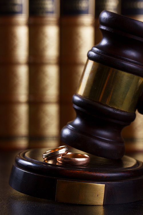 Law and justice - close up of law gavel with two rings, divorce concept