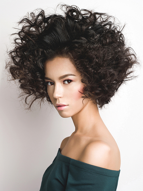 Fashion studio portrait of beautiful woman  with afro curls hairstyle. Fashion and beauty