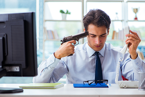 Angry businessman with gun thinking of committing suicide