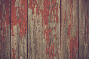 Red paint pealing off old wooden planks