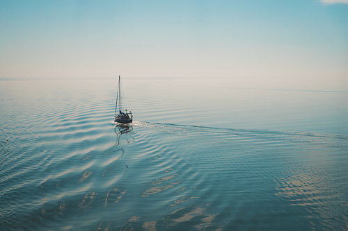 Sailing boat traveling in the calm open sea. Blurred motion image with instagram effect