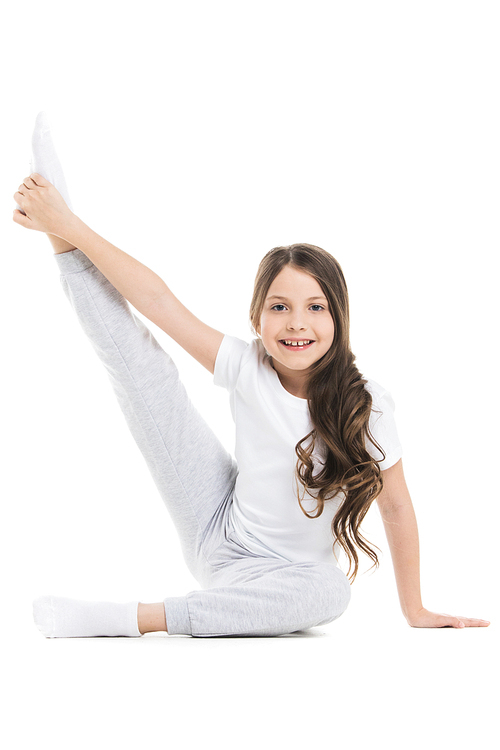 Small girl doing stretching leg exercise isolated on white