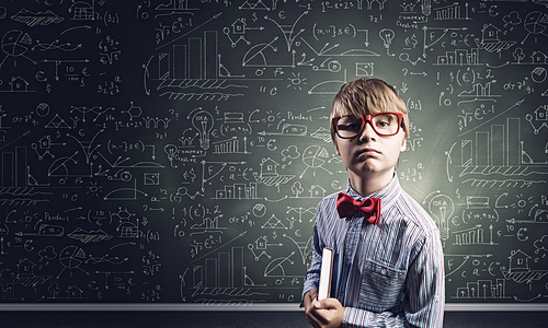 Genius boy in red glasses near blackboard with formulas