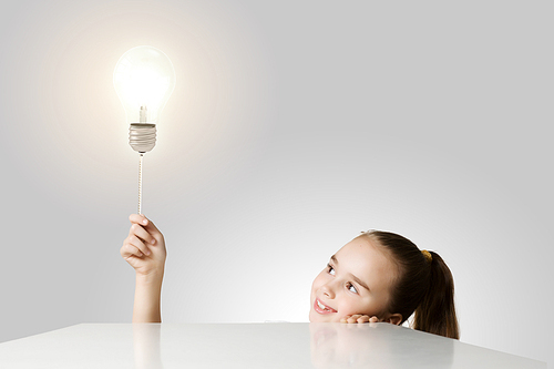 Little cute school girl and electric bulb