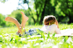 Child lying on blanket having picnic in summer park