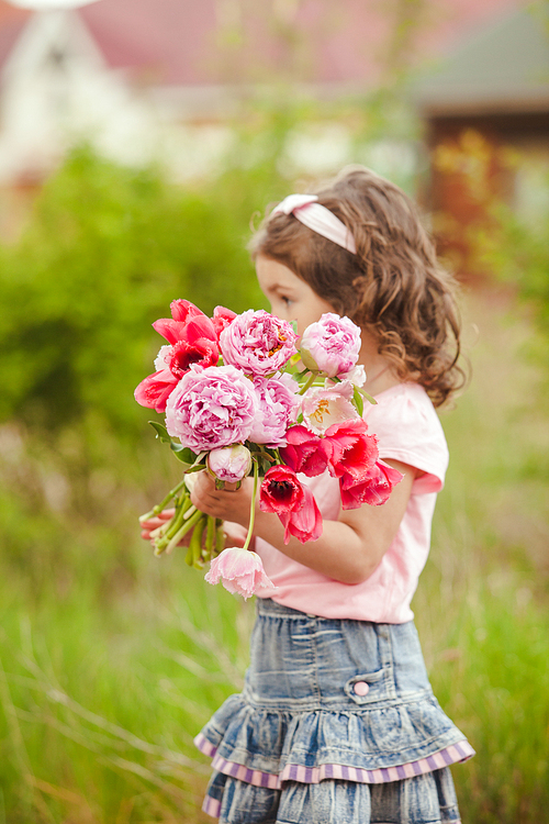 Girl with bouquet of pink flowers for mom on mother's day selebratinf