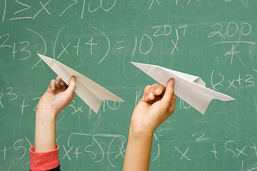 Two students about to throw paper aeroplanes