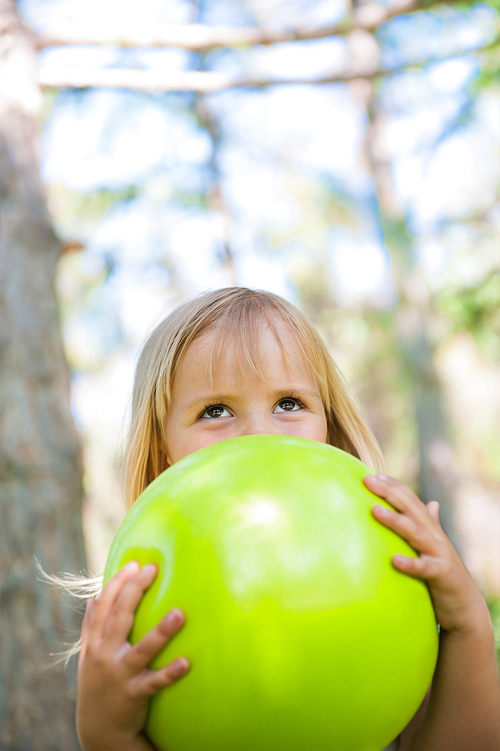 Little girl playing with green ball in the park