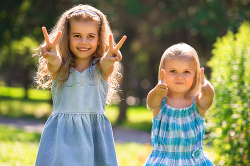 Happy childhood: Little girls having fun together outdoors in park