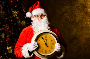 Santa Claus holding clock with countdown to Christmas or New Year