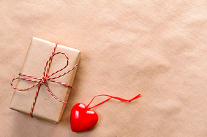 Heart with handmade gift box wrapped with craft paper and red bow for Valentine's day