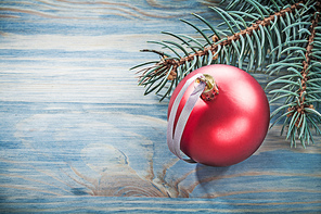 Pine branch red shining bauble on wooden board celebrations concept.