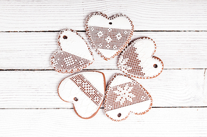 Gingerbread cookies in shape of heart with icing on a wooden background