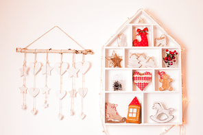 Wooden shelves in shape of cozy home with Christmas decorations