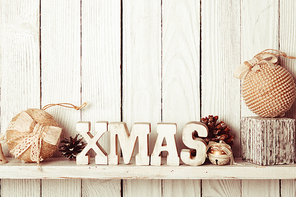 Christmas decor on the shelf - wooden letters XMAS over wooden wall