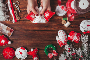 felt Christmas decorations on the wooden table - woman is preparing for handmade