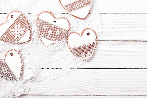 Gingerbread cookies in shape of heart with icing on a crochet doily, copy space