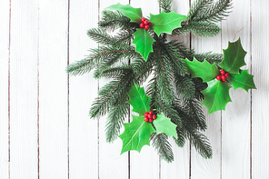Cristmas Holly berry and fir twigs on the white wall