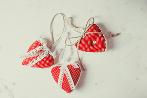 Red polka dot textile hearts hon the table. Process of sewing and design