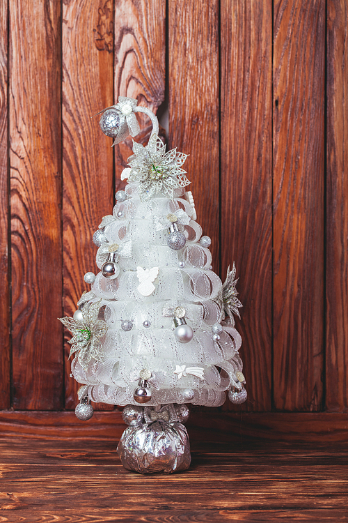 Silver Handmade Christmas tree over wooden background, copy space