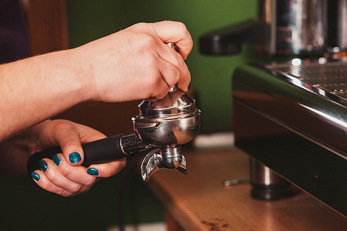 Close-up barista grinding coffee for flavored espresso
