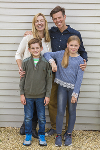 Portrait shot of an attractive, successful and happy family, man, woman, girl and boy child, mother, father, son and daughter outside