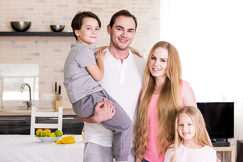 Portrait of happy family with two children at home