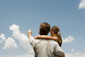 Father and daughter looking at clouds