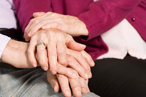 Elderly couple with hands together