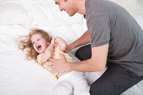 father tickling his daughter