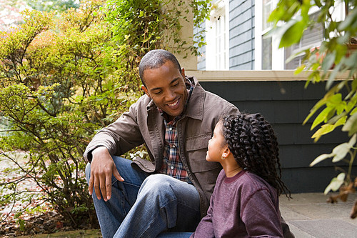 Father and daughter outside house