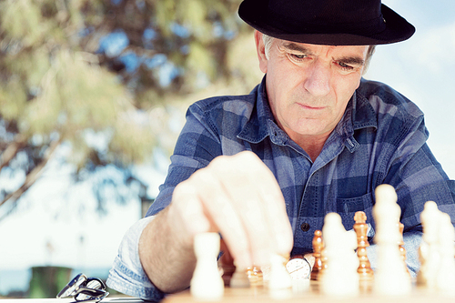 Elderly man sitting outdoors with chess