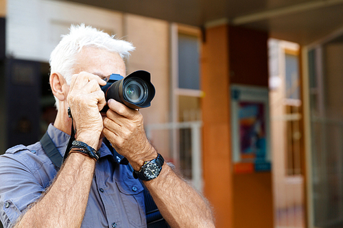 Senior man with camera in city